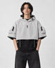 Model wearing the light gray cropped hooded poncho top over a black tee, front view