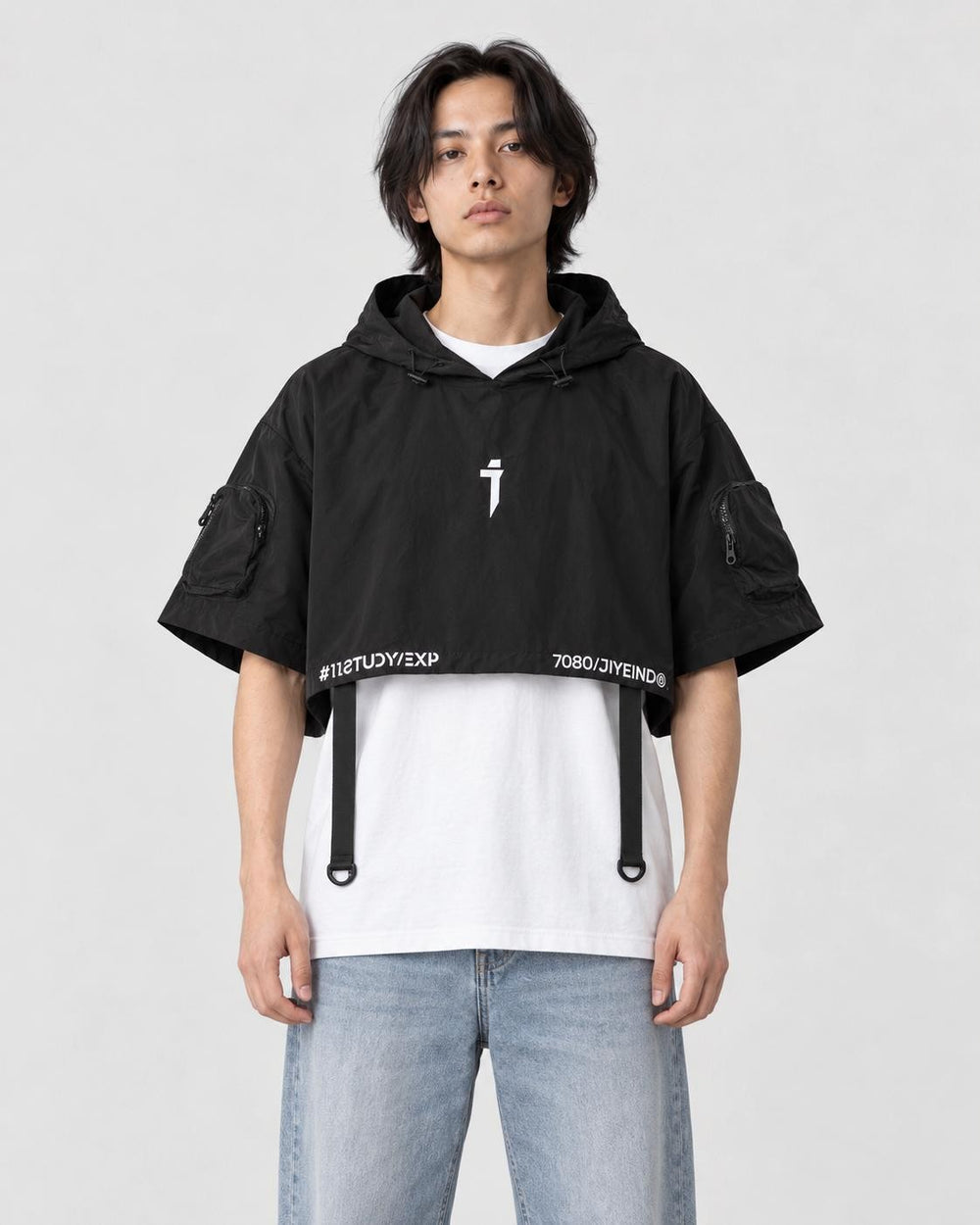 Model wearing the black cropped poncho top over a white tee, front view