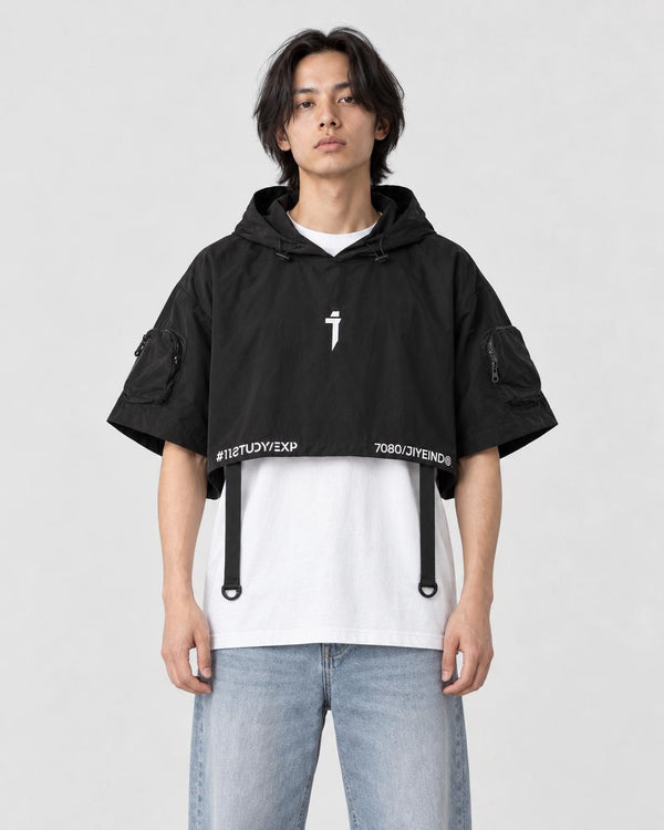 Model wearing the black cropped poncho top over a white tee, front view