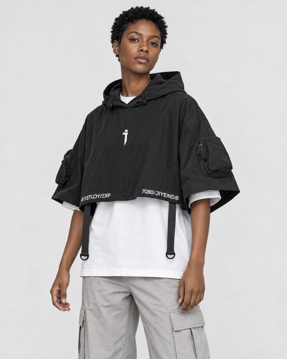 Model wearing the techwear poncho top with stone trousers, three-quarter view