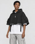 Model wearing the techwear poncho top with stone trousers, three-quarter view