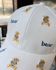 Close-up of the tan teddy bears and navy bear lettering embroidered on the white cap