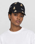 Model wearing the black teddy bear embroidered cap with a white tee, side view