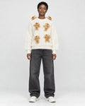 Model wearing the cream teddy bear sweater with black jeans, front view