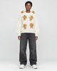 Model wearing the cream teddy bear sweater with black jeans, front view