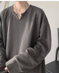 Close-up of the raised vertical rib texture, the neckband and the V notch on the dark gray tee