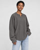 Model wearing the dark gray textured long sleeve tee with light-wash jeans, three-quarter view