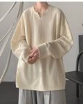 Cream ribbed long sleeve tee with a notched V neckline, worn with gray trousers