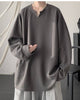 Dark gray ribbed long sleeve tee with a notched V neckline, worn with gray trousers