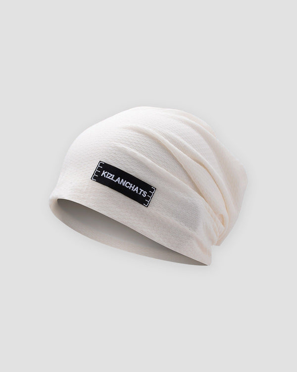 White slouchy beanie in a thin honeycomb knit with a small black woven label on the front