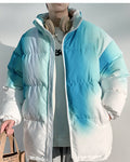 Blue-green tie-dye puffer jacket carried with a tote bag, torso view