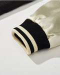 Close-up of the cream satin-like sleeve and striped rib cuff