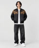 Model wearing the black tiger and dragon bomber jacket, front view with gold dragons on the chest