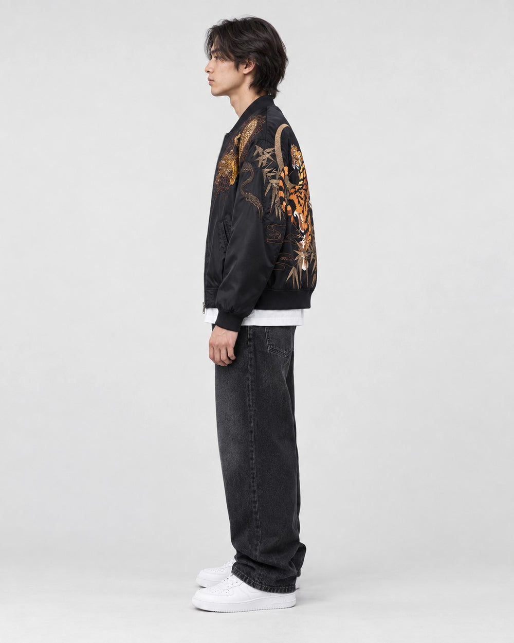 Model wearing the black tiger and dragon bomber jacket, side view