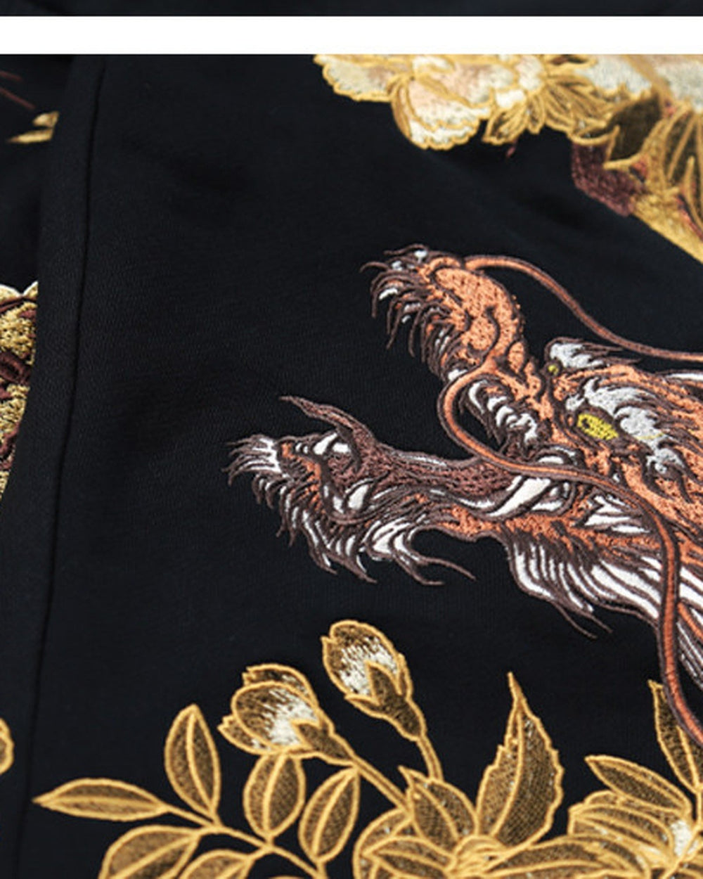 Close-up of the embroidered dragon among gold leaves