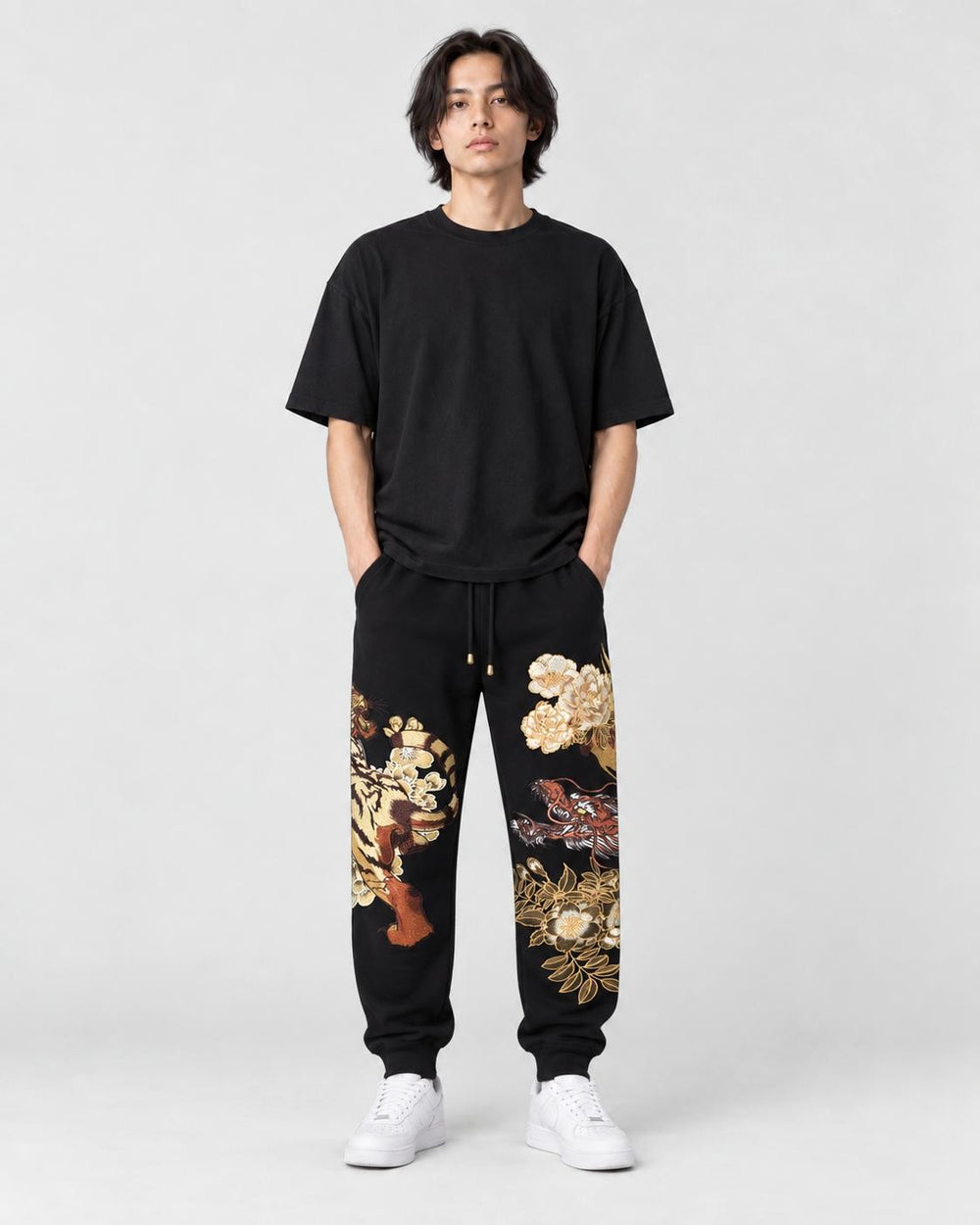Model wearing the black tiger dragon embroidered joggers, front view