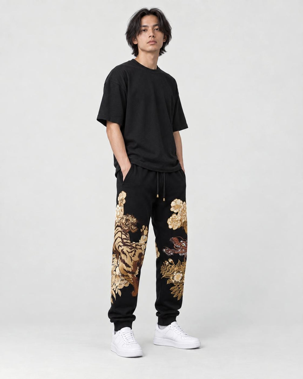 Model wearing the tiger dragon joggers, three-quarter view of the embroidery