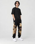 Model wearing the tiger dragon joggers, three-quarter view of the embroidery