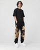 Model wearing the tiger dragon joggers, three-quarter view of the embroidery