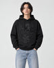Model wearing the black dragon embroidered hoodie with light-wash jeans, front view