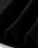 Close-up of the ribbed cuffs and hem of the black sweatshirt