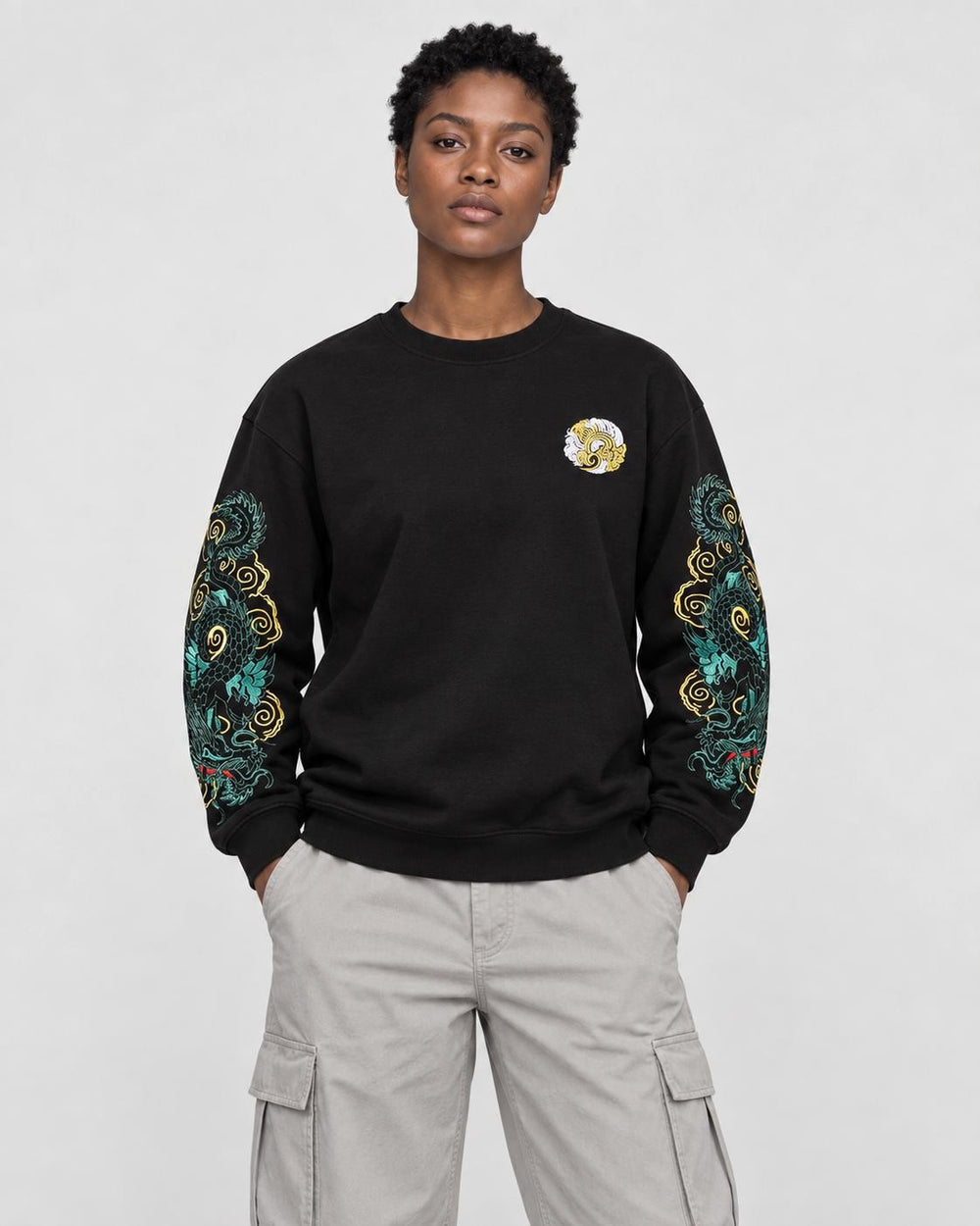 Model wearing the black twin dragon sleeve sweatshirt with stone trousers, front view