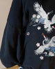 Close-up of the two embroidered cranes on the back of the black hoodie