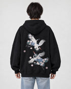 Model wearing the black crane embroidered hoodie with light-wash jeans, back view