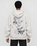 Model wearing the oatmeal crane embroidered hoodie with black jeans, back view