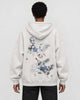 Model wearing the oatmeal crane embroidered hoodie with black jeans, back view