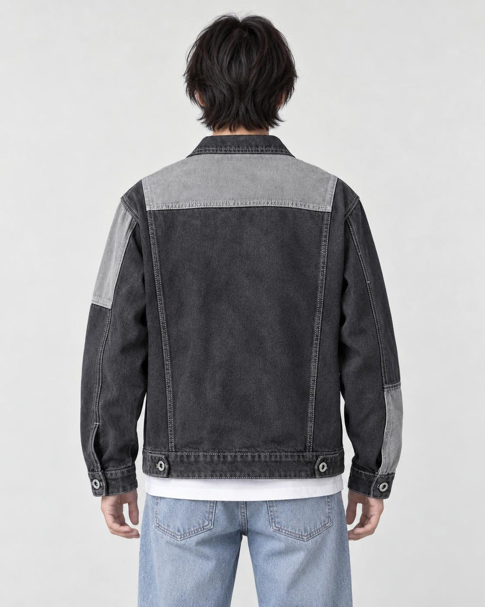 Model wearing the dark gray patchwork denim jacket, back view of the light yoke