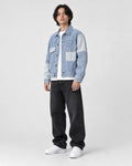 Model wearing the light blue patchwork denim jacket, three-quarter view