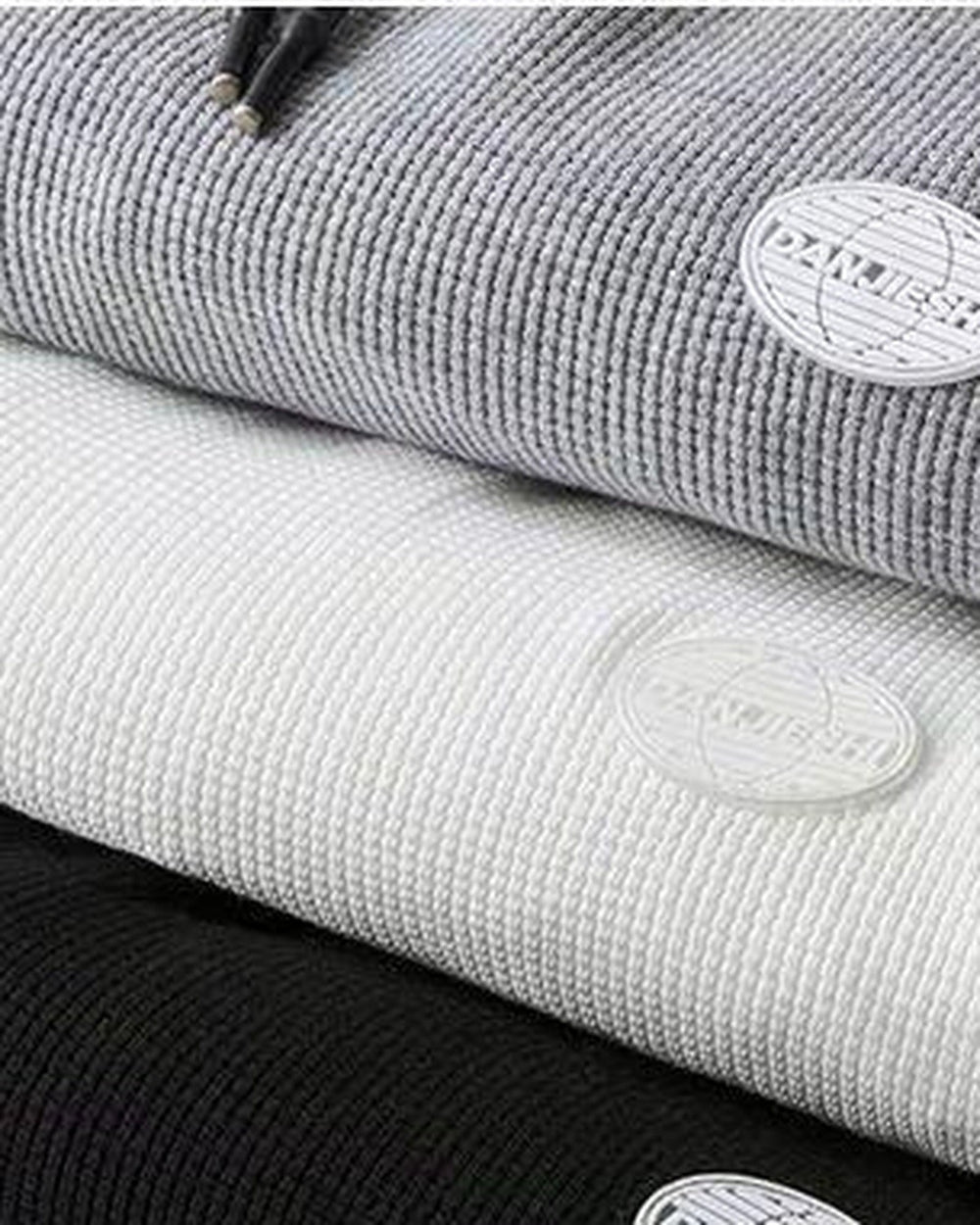 Close-up of the waffle texture and round patch label on the gray and white joggers
