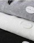 Close-up of the waffle texture and round patch label on the gray and white joggers