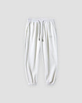 White waffle knit joggers with a white drawcord and ribbed ankle cuffs, front view
