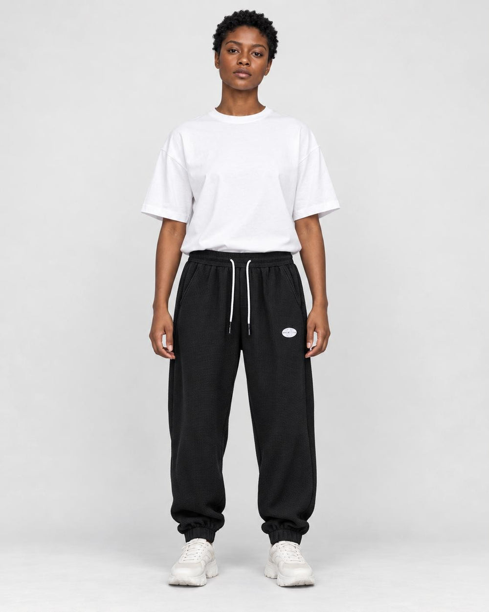 Model wearing the black waffle knit joggers with a white tee, front view