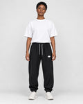 Model wearing the black waffle knit joggers with a white tee, front view