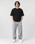 Model wearing the gray waffle knit joggers with a black tee, front view