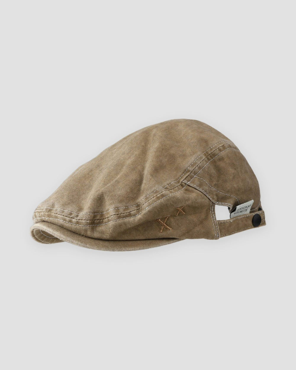 Khaki washed flat cap with a short peak, cross stitches and a white woven tab