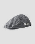 Washed black flat cap with a short peak, cross stitches and a white woven tab
