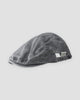 Washed black flat cap with a short peak, cross stitches and a white woven tab