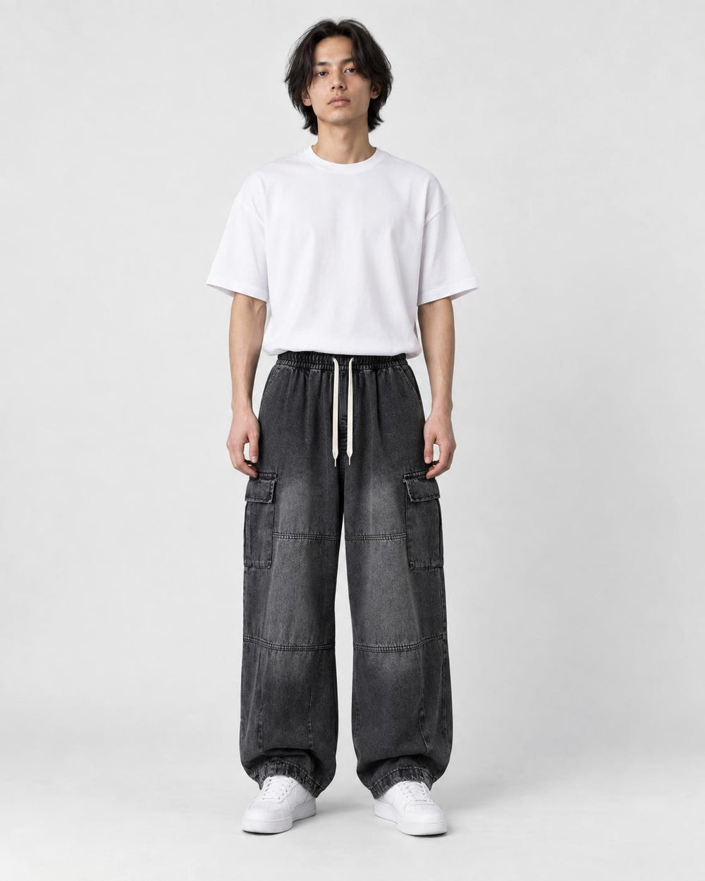 Model wearing the washed black wide-leg cargo jeans, front view