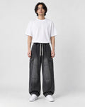 Model wearing the washed black wide-leg cargo jeans, front view