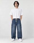 Model wearing the blue washed wide-leg cargo jeans with a white tee, front view
