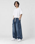 Model wearing the blue cargo jeans, three-quarter view of the thigh pocket