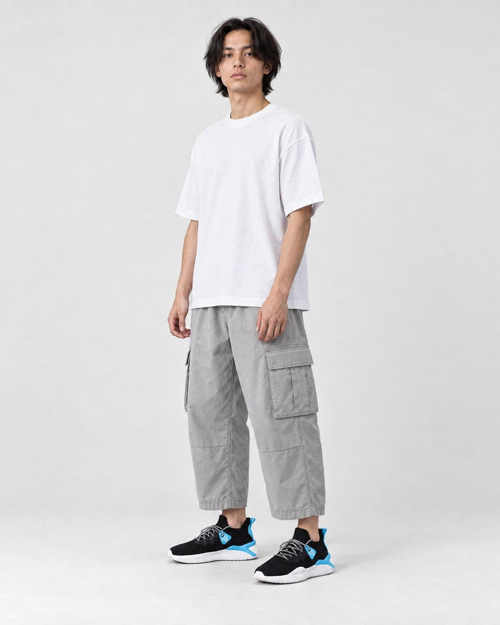 Model wearing the black and blue knit sock sneakers, three-quarter view