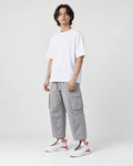 Model wearing the white knit sock sneakers with cropped gray cargo pants