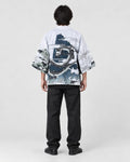 Full-length back view of a man in the white haori with a coiling gray dragon and waves, black tee and black jeans