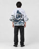 Full-length back view of a man in the white haori with a coiling gray dragon and waves, black tee and black jeans