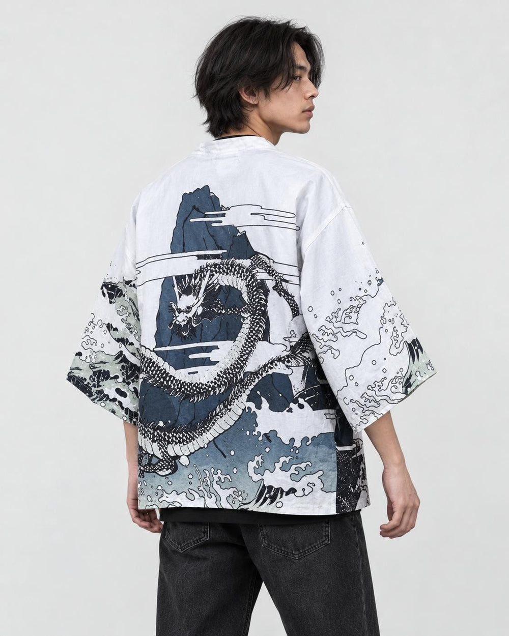 Man in the white haori seen from behind at an angle, with a coiling gray dragon and black and white waves, over a black tee